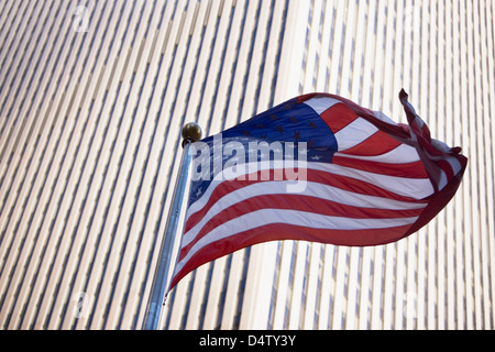 American flag flying by city skyscraper