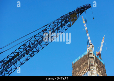 Low angle view of crane and skyscraper Stock Photo