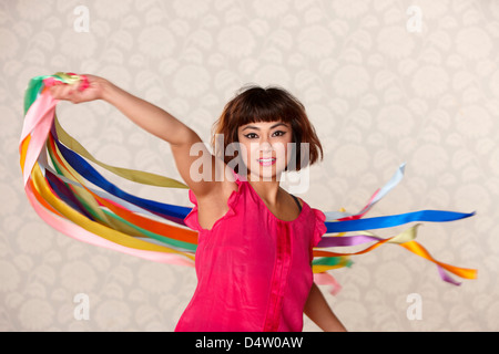 Woman playing with ribbon streamers Stock Photo