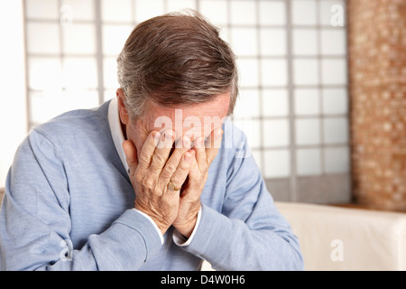Older man covering face with hands Stock Photo