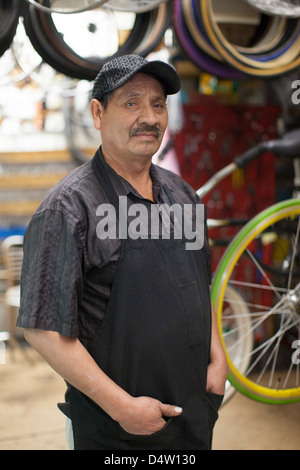Mechanic standing in bicycle shop Stock Photo