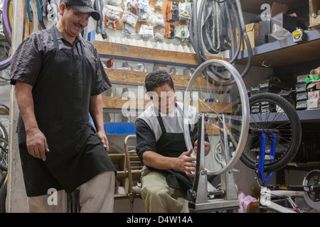 Mechanics working in bicycle shop Stock Photo