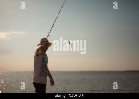 Man displaying lure on fishing line Stock Photo
