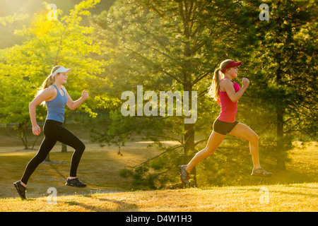 Teenage girls running together in field Stock Photo