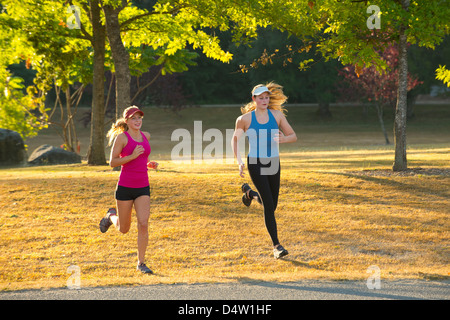 Teenage girls running together in field Stock Photo