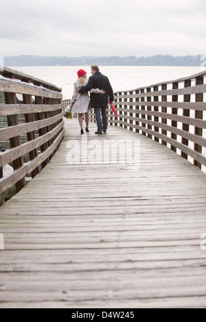 Couple walking on wooden dock Stock Photo