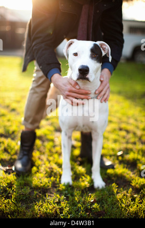 Man holding dog in park Stock Photo