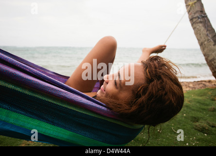 Woman relaxing in hammock on beach Stock Photo