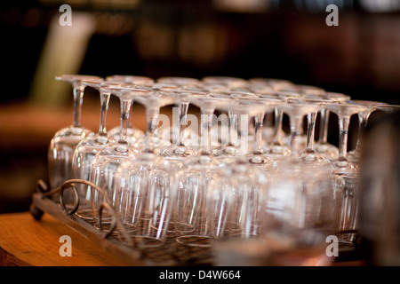 Upturned wine glasses in rack Stock Photo
