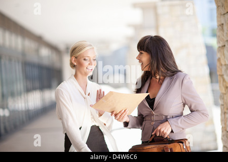 Businesswomen talking in walkway Stock Photo