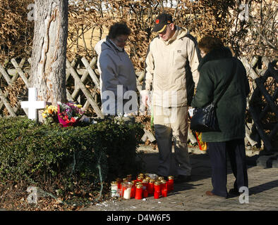 Residents stand in front of the house that has burnt down in Unna, Germany, 26 December 2009. Five people died and two were severly injured in a fire for yet unclear reasons on 25 December 2009. Many people laid down flowers and lit candles in front of the house. Photo: Roland Weihrauch Stock Photo