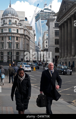 People workers walking past Mansion House with a view of Walkie-Talkie building under construction in City of London UK 2013 Stock Photo