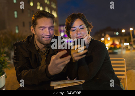Couple using cell phones outdoors Stock Photo