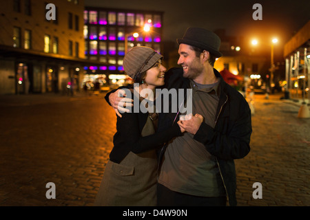 Couple hugging on city street Stock Photo