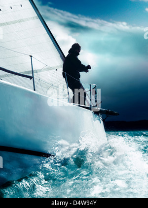 Man trimming sails on yacht in race Stock Photo
