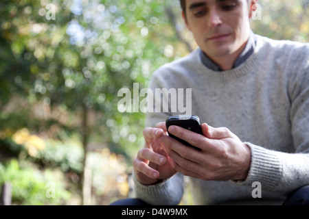 Man using cell phone outdoors Stock Photo