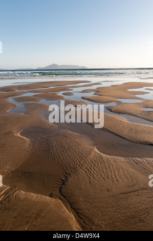 Water making patterns in sand on beach Stock Photo