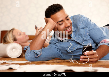 Man listening to headphones on bed Stock Photo