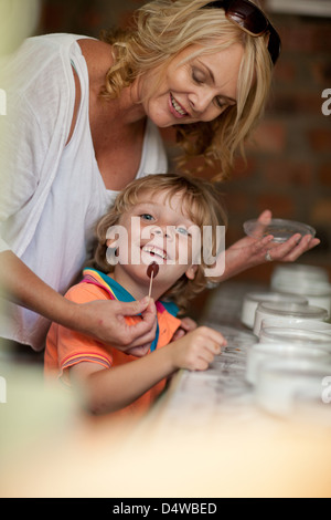 Mother giving son olive to taste Stock Photo