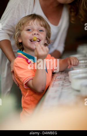 Smiling boy displaying olive in grocery Stock Photo