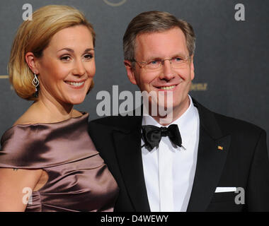 German President Christian Wulff and wife Bettina pose for a picture on the red carpet of the German Press Ball at Hotel Intercontinental in Berlin, Germany, 26 November 2010. The German Press Ball is a gathering of celebrities, politicians, businessmen, socialites and media representatives. Photo: Jens Kalaene Stock Photo
