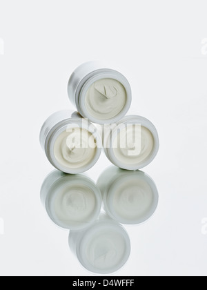 Pots of lotion stacked on counter Stock Photo