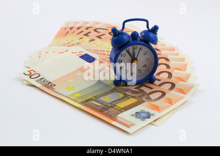 Time is money concept with miniature clock on banknotes Stock Photo