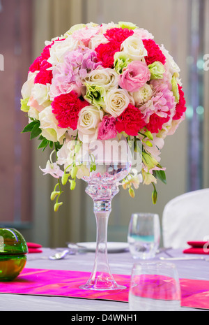Flower bouquet in glass vase on dining table Stock Photo