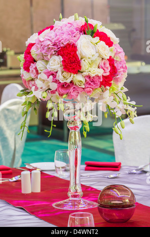 Flower bouquet in glass vase on dining table Stock Photo