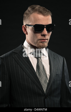 Fashion man in suit wearing sunglasses. Studio shot. Stock Photo