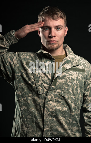 Military young man salutes. Studio portrait. Stock Photo