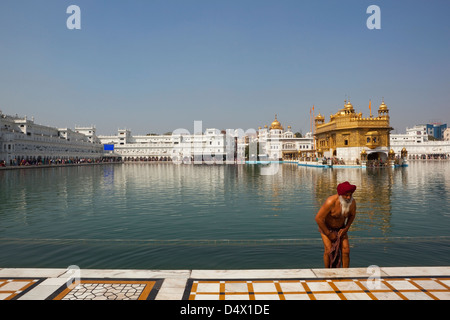 A male  Sikh devotee taking a bath in the Holy Pool at the magnificent Golden Temple in Amritsar, Punjab, India. Stock Photo