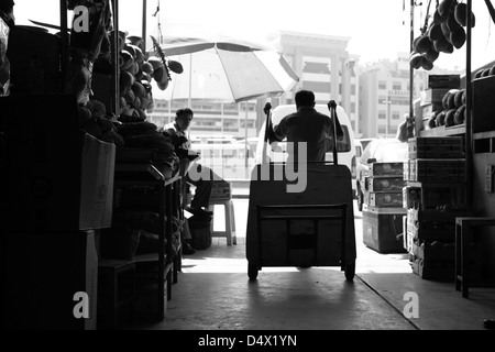 Silhouette of man pulling cart at market in Dubai, United Arab Emirates Stock Photo