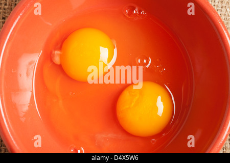 Two broken eggs in a bowl Stock Photo