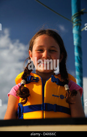Schoolgirl wearing a life jacket on board a sailing boat in Ireland Stock Photo