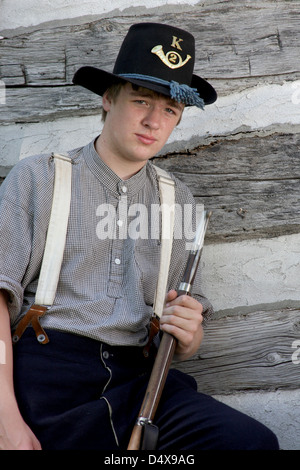 A Civil War boy soldier in front of a log cabin Stock Photo