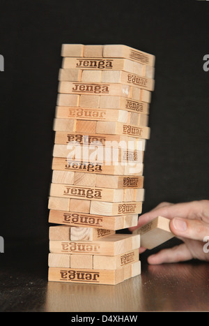 The game of Jenga. The tower of brick blocks collapses as one section is removed. Stock Photo