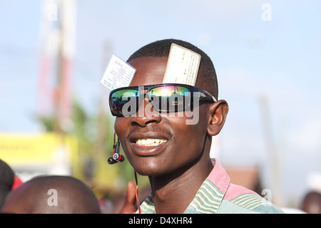 A voter shows of his ID and voters card at a queue leading into the New Kihumbuini Primary School polling station. © David Mbiyu/Alamy Live News Stock Photo