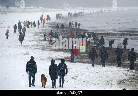 People walk at the beach of Binz on the island of Ruegen, Germany, 20 March 2013. Heavy snowfalls hit the north of Germany during the night. Photo: STEFAN SAUER Stock Photo