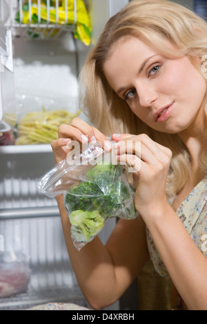 woman put frozen veggies in freezer Stock Photo