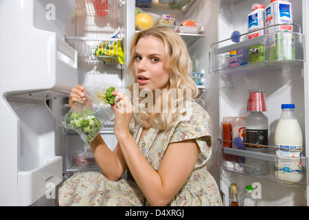 woman put frozen veggies in freezer Stock Photo