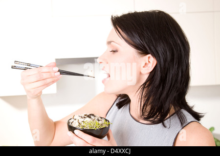 Woman eating rice with chopsticks Stock Photo