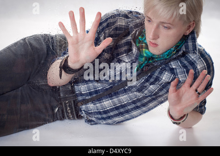 the sad young man leaned hands against wet glass Stock Photo