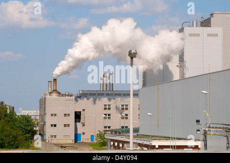 Factory pipes and building on a background of the blue sky with clouds Stock Photo