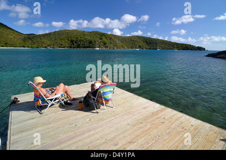 Couple relaxing on pier at Great Lameshur Bay, St. John, U.S. Virgin Islands. Stock Photo
