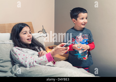 Children watch TV in bed Stock Photo