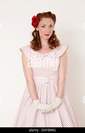 Redhead woman in a vintage dress with a coy expression Stock Photo
