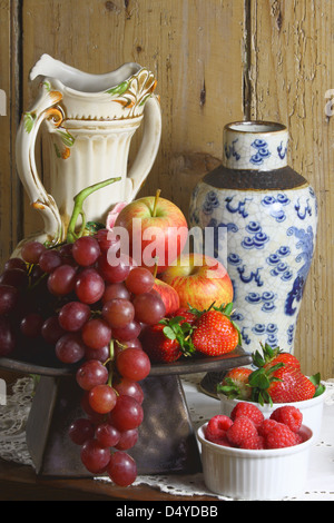 A still life photo of fruit and berries with accompanying vases. Stock Photo