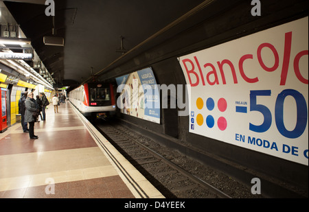 Advertising hoarding and train. Barcelona Metro. The city underground rail system. Barcelona, Spain. Stock Photo