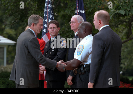 President George W. Bush shakes hands with a police officer Tuesday, Sept. 18, 2001, in the Rose Garden of the White House after thanking charitable organizations for their relief efforts at the World Trade Center and Pentagon and announcing the creation of the American Liberty Partnership. Photo by Paul Morse, Courtesy of the George W. Bush Presidential Library Stock Photo